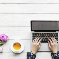 Aerial view of a woman using computer laptop working and hot tea